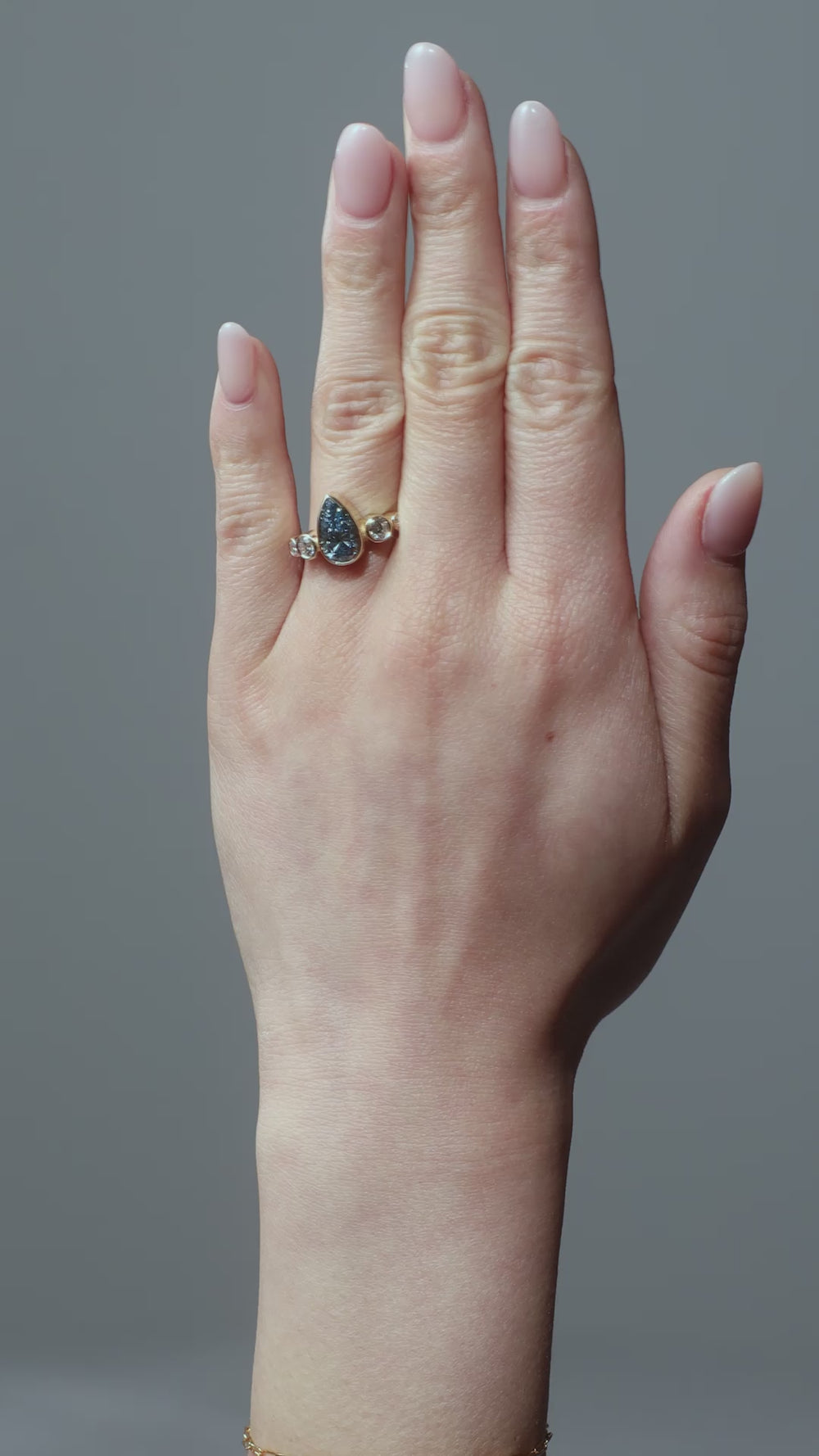 Gold ring with a teardrop-shaped blue diamond  centre stone with round diamonds